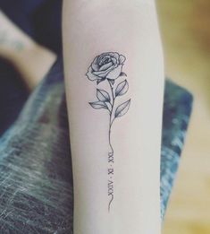 a small rose tattoo on the left arm