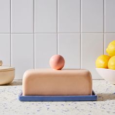 a cake sitting on top of a counter next to some lemons and a bowl