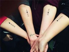 three people holding hands with tattoos on their arms