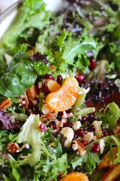 a salad with oranges, nuts and cranberries in it on a plate