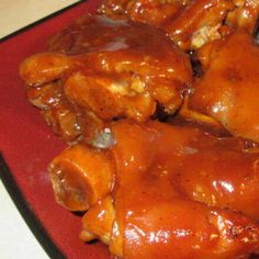 a red plate topped with chicken wings covered in gravy