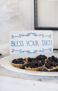 a plate with blueberries on it and a sign that says, blessing your tart