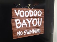 a sign that says voodoo bayou no swimming on the side of a black door