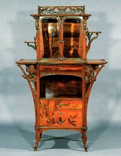 an ornate wooden cabinet with mirror on top