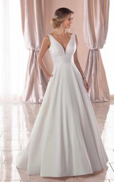 a woman in a white wedding dress standing on a tile floor