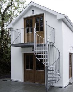 a white house with a metal spiral staircase