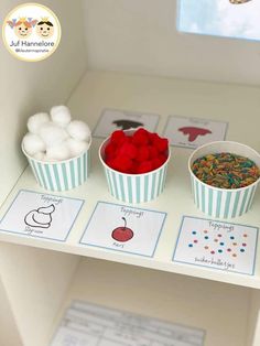 three cups filled with different types of food on top of a shelf in a room