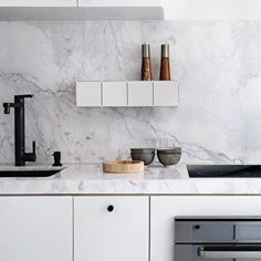 a kitchen with marble counter tops and white cabinets