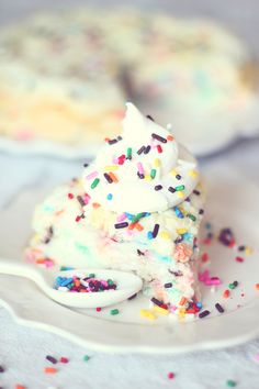 a piece of cake with sprinkles on it is sitting on a plate