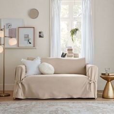 a living room with a couch, lamp and pictures hanging on the wall above it