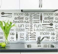 a kitchen wall with words written on it and a potted plant in the middle