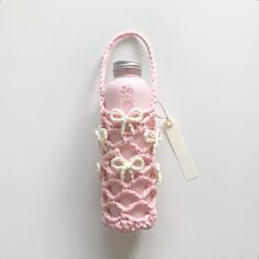 a pink water bottle with a white bow on it