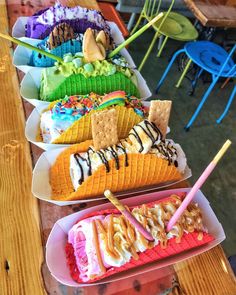 several trays filled with different types of ice cream and waffle sundaes