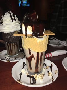 two desserts are sitting on the table with chocolate sauce and ice cream in them