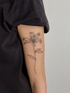 a woman's arm with a flower tattoo on the left side of her arm