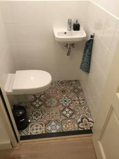 a white toilet sitting next to a sink in a bathroom