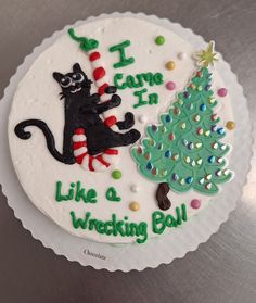 a cake decorated to look like a christmas tree with a cat sitting on it and the words i came in like a wrecking ball