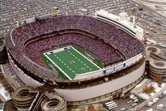 an aerial view of a football stadium with snow on the ground and cars parked in the parking lot