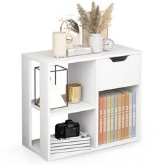 a white book shelf with books, plants and other items on it's shelves