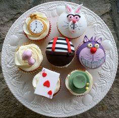 there are many cupcakes on the plate and one is decorated like a cat