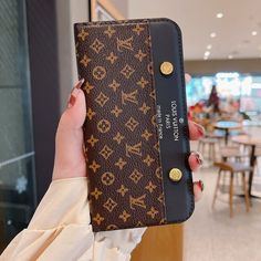 a woman holding up a brown and black case in her hand with the word louis vuitton on it