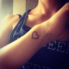 a woman with a heart tattoo on her arm