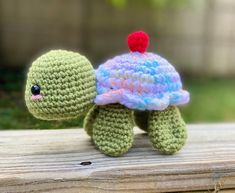 a crocheted turtle sitting on top of a wooden table