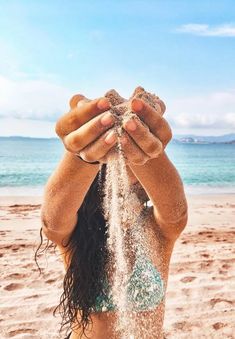 a woman covered in sand on the beach