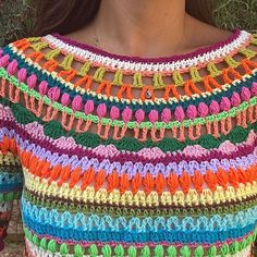 a woman wearing a multicolored crochet top