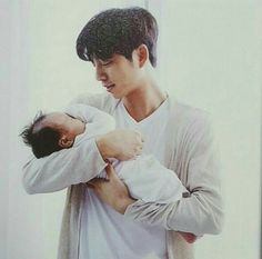 a man holding a baby in his arms