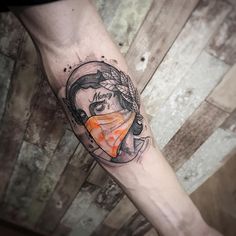 a woman's leg with a tattoo on it that has an orange and black design