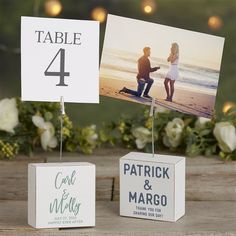 the table numbers are placed on small boxes with photos attached to them, along with flowers and candles