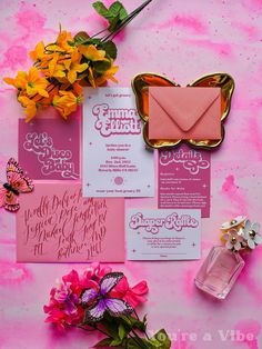 pink and white wedding stationery with envelopes, flowers, and butterflies on a pink background