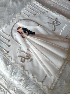 a wedding dress is laying on top of a white furnishing with the bride's monogrammed initials