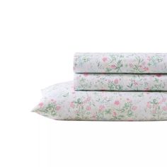 three sheets with pink and green flowers on them, one is folded up to the side