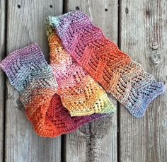 two knitted mittens sitting on top of a wooden table