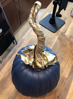 a blue pumpkin sitting on top of a wooden table