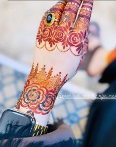 a woman's hand with henna tattoos on it