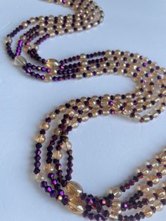 Double Strand Waist Bead, a stunning blend of purple crystal glass beads with elegant gold and brown accents. Why You'll Love It: Exquisite Sparkle: Beautiful purple crystal glass beads create a radiant, eye-catching shimmer. Elegant Accents: Gold and brown crystal glass beads add a touch of luxury and sophistication. Perfect Fit: The adjustable double strand design ensures comfort and a secure fit for all body types. Cultural Beauty: This piece reflects the rich heritage of Ivorian craftsmanshi Brown Faceted Beads Necklace For Party, Elegant Brown Beads For Parties, Elegant Single Strand Brown Beads, Elegant Brown Spacer Beads, Elegant Brown Beaded Crystal Necklaces, Elegant Brown Beaded Crystal Necklace, Polished Purple Beads For Party, Purple Glass Beaded Necklaces With Round Beads, Purple Polished Beads For Party