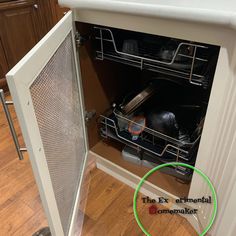 an empty dishwasher in the middle of a kitchen cabinet with a green circle around it