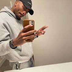 a man taking a selfie in front of a mirror with his cell phone up to his ear