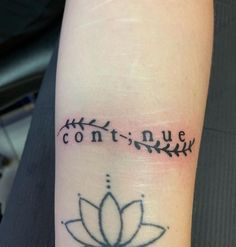 a lotus tattoo on the wrist that says contin nue and is written in cursive writing