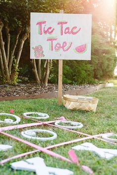 there is a sign that says tie tac toe on the grass in front of a yard