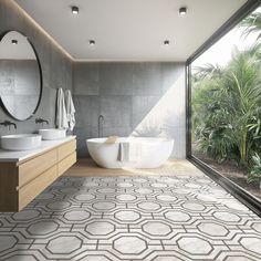 a bathroom with two sinks and a large bathtub in the center, surrounded by greenery