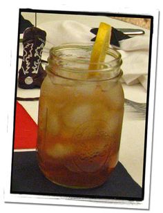 a mason jar filled with liquid and a lemon wedge