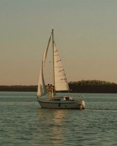 two people on a sailboat in the water