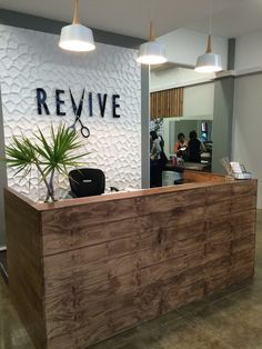 the front desk of a hair salon with a potted plant on it's side