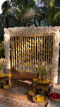 an outdoor area with flowers and decorations on the ground, including a bench made out of wood