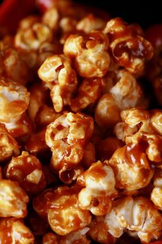 caramel popcorn is sitting in a red bowl