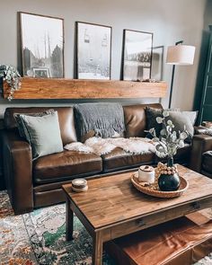 a living room with couches, tables and pictures hanging on the wall above them